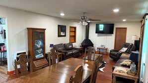 Amplia sala de estar con mesa de comedor de madera, sofás de cuero y chimenea.