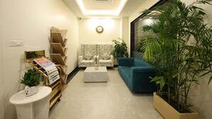 A modern living room with a sofa, a coffee table, and a bookshelf. - Rukman Hotels Jaipur (Jaipur)
