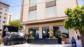 A multi-story hotel with a modern design, featuring large windows and a flat roof with a railing. - Rukman Hotels Jaipur (Jaipur)