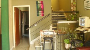 Uma escadaria com corrimão, uma mesa com computador e uma cadeira.
