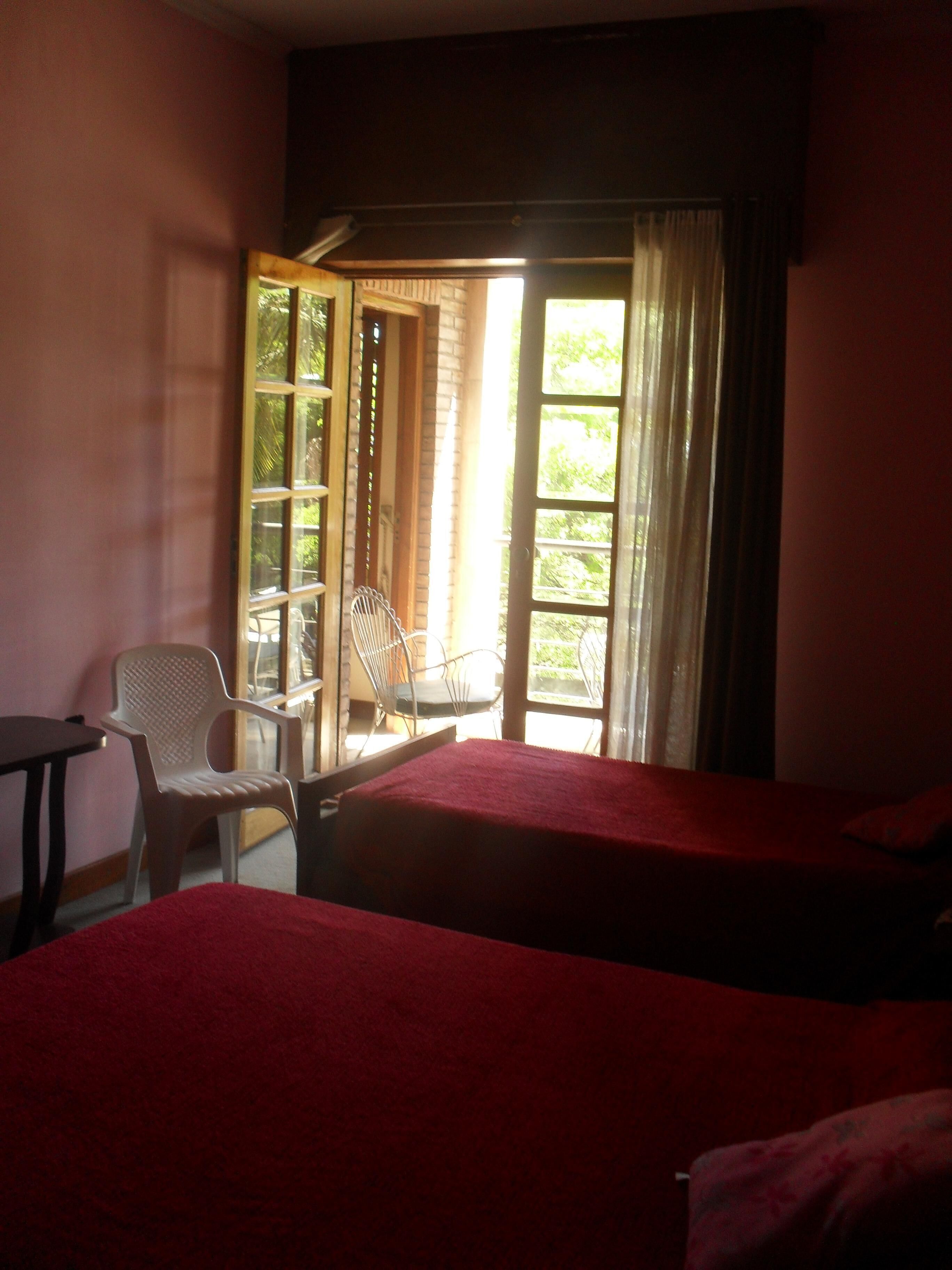 A room with two beds, a chair, and a table.