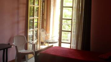 A room with two beds, a chair, and a table.