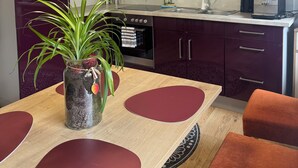 Una cocina moderna con armarios oscuros, horno empotrado y cafetera.