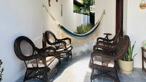 A covered outdoor seating area with wicker furniture and a hammock. - Beach House in Praia dos Carneiros/PE, one of the most beautiful beaches in Brazil (Tamandaré)