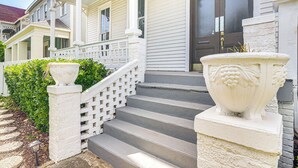 A two-story house with a porch, a front door, and a staircase leading to the entrance. - Walk to Strand District: Historic Galveston Home (Galveston)