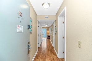 Un couloir doté d’un plancher en bois, de murs de couleur beige et d’une porte portant l’inscription « 330 ».