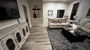 Un salon avec une cheminée, un canapé, une table basse et un téléviseur.