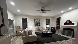 Un salon comprenant un canapé, des fauteuils, une table basse et une cheminée.