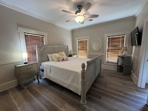 A bedroom with a bed, a ceiling fan, a nightstand, a lamp, and a television. - 4-bedroom estate Downtown Cleveland WiFi, Pool, massage chair Kitchn Holidays (Cleveland)