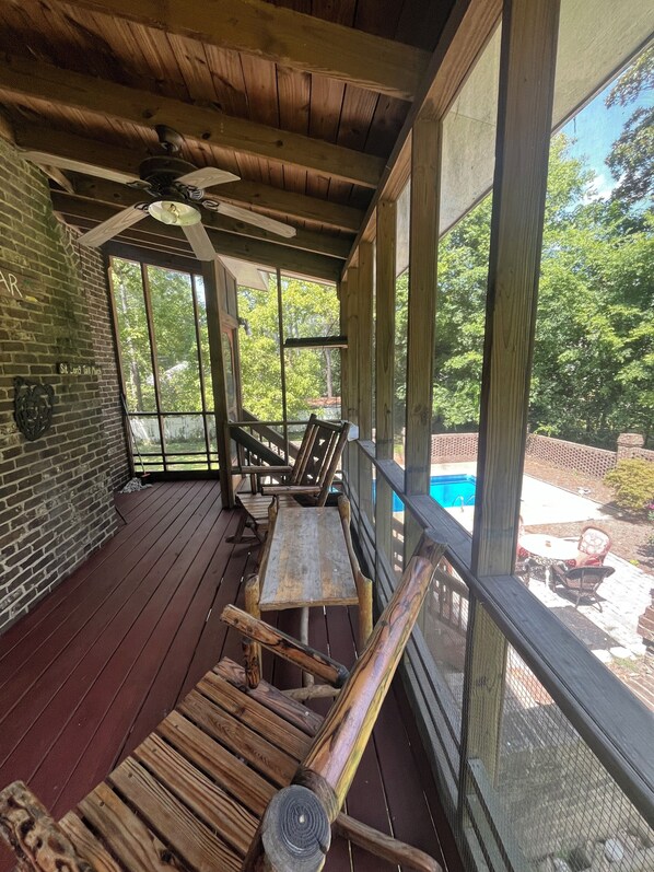 A covered outdoor area with a wooden deck, a ceiling fan, and a view of a swimming pool. - 4-bedroom estate Downtown Cleveland WiFi, Pool, massage chair Kitchn Holidays (Cleveland)