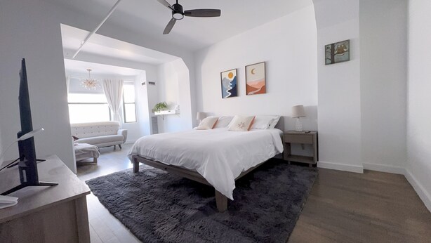 A modern bedroom with a large bed, a ceiling fan, and a view of a balcony. - Premium Loft 3BR&2BA • Heart of Downtown Boston • Guest Favorite (Boston)