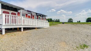 A building with a white exterior and red accents, featuring a covered outdoor area with a gravel ground. - 5 Mi to Dtwn Sweetwater: Studio w/ Serene Views (Sweetwater)