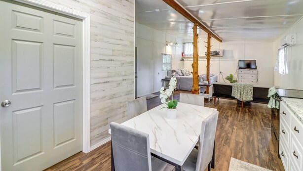 A dining area with a white marble table, grey chairs, and a potted plant. - Ozark Escapes Cabin! Serene Forest & Mtn Setting (Harrison)
