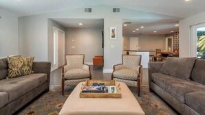 A spacious living room with two sofas, a coffee table, and patterned chairs. - Delray Beach Tropical Retreat (Delray Beach)