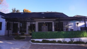 A building with a covered entrance, a sign reading "KAIRO", and a well-maintained garden area. - 12-bedroom bed guest house in charming Bedfordvew with WiFi, AC (Germiston)