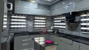 Una cocina moderna con encimeras de mármol, electrodomésticos de acero inoxidable y una isla central.