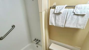 A bathroom with a bathtub, toilet, and towel rack.