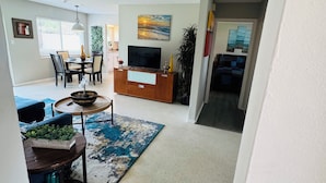 A spacious living room with a dining area, a TV, and a large window. - Entire place in the heart of Sarasota (Sarasota)