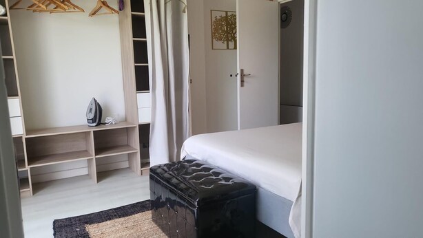 A bedroom with a bed, a wardrobe, and a bench.