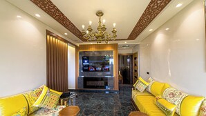 A modern living room with a fireplace, yellow sofas, and a wooden coffee table.