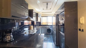 A modern kitchen with stainless steel appliances, a built-in oven, and a large window providing natural light.