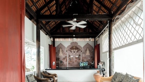 A spacious room with wicker furniture, a ceiling fan, and a mural on the wall. - Lanna Oriental Mae Rim (Mae Rim)