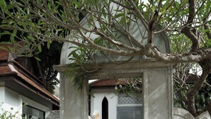 A stone archway with statues, surrounded by greenery and a stone wall. - Lanna Oriental Mae Rim (Mae Rim)