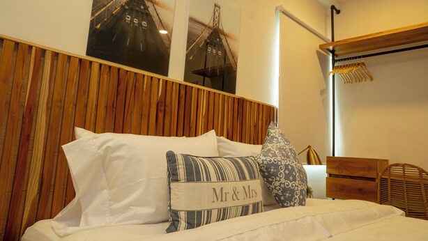 A neatly made bed with white linens and a pillow labeled "Mr & Mrs". - Casa Ramona Boutique Rooms (Cartagena)