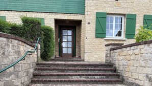 A set of stone steps leading to a building with a green door and shutters. - ☀️ Apartment in a quiet residence located 20 m from the beach ☀️ (Houlgate)