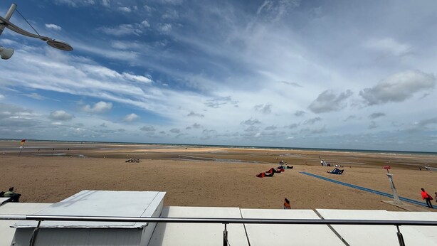 A beach with a clear sky, a sandy shore, and a few people and kites. - ☀️ Apartment in a quiet residence located 20 m from the beach ☀️ (Houlgate)