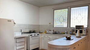 A kitchen with white cabinets, a stove, a refrigerator, and a window with patterned glass. - 3-bedroom house in terrific Coronado Beach with WiFi, AC, BBQ area (Las Lajas)