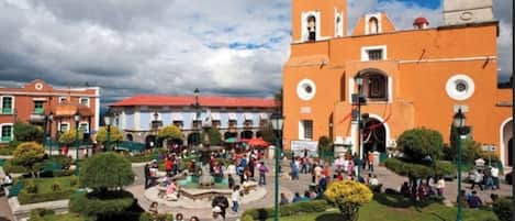 A public square with a central fountain, surrounded by buildings with distinct architectural styles.