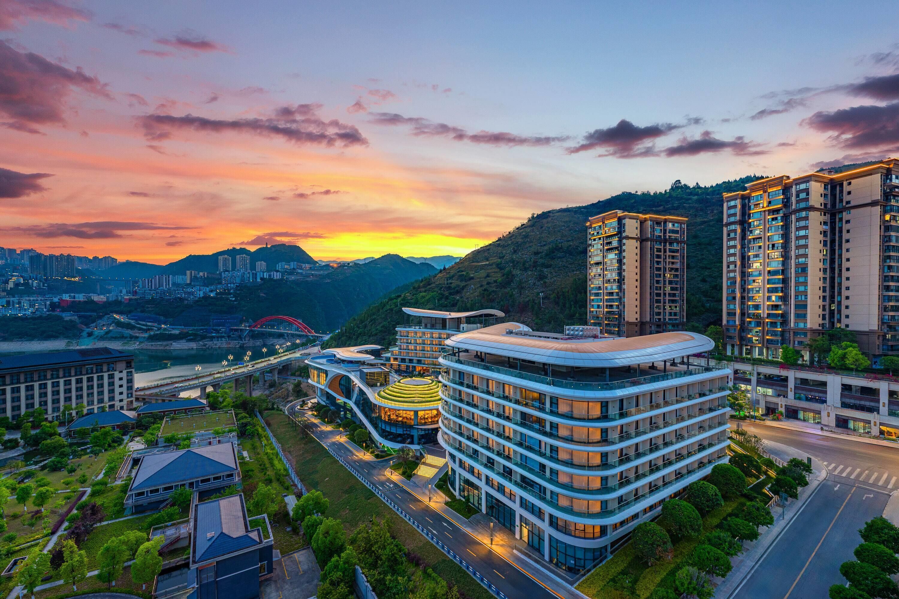 Una zona urbana moderna con edificios altos, un puente y un río.