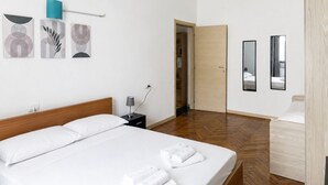 A hotel room with a bed, a bedside table, a lamp, and a wardrobe.