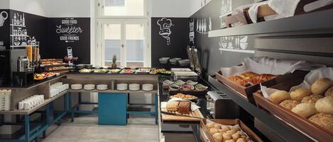 A buffet setup with various food items and a chef's hat decoration on the wall.