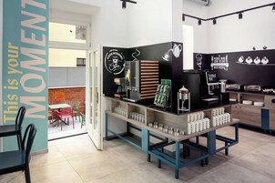 Un interno di un bar con un bancone, zona salotto e decorazioni alle pareti.