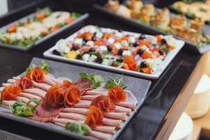 Een buffet met diverse gerechten, waaronder vleeswaren, kazen en salades.