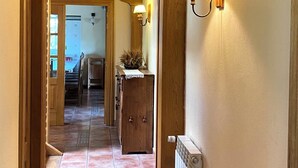 A hallway with wooden beams, a radiator, and a sign indicating an exit.