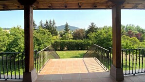 A covered outdoor area with a view of a mountain and greenery.