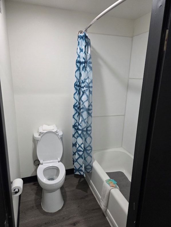 Un baño pequeño con inodoro, cortina de ducha y bañera.