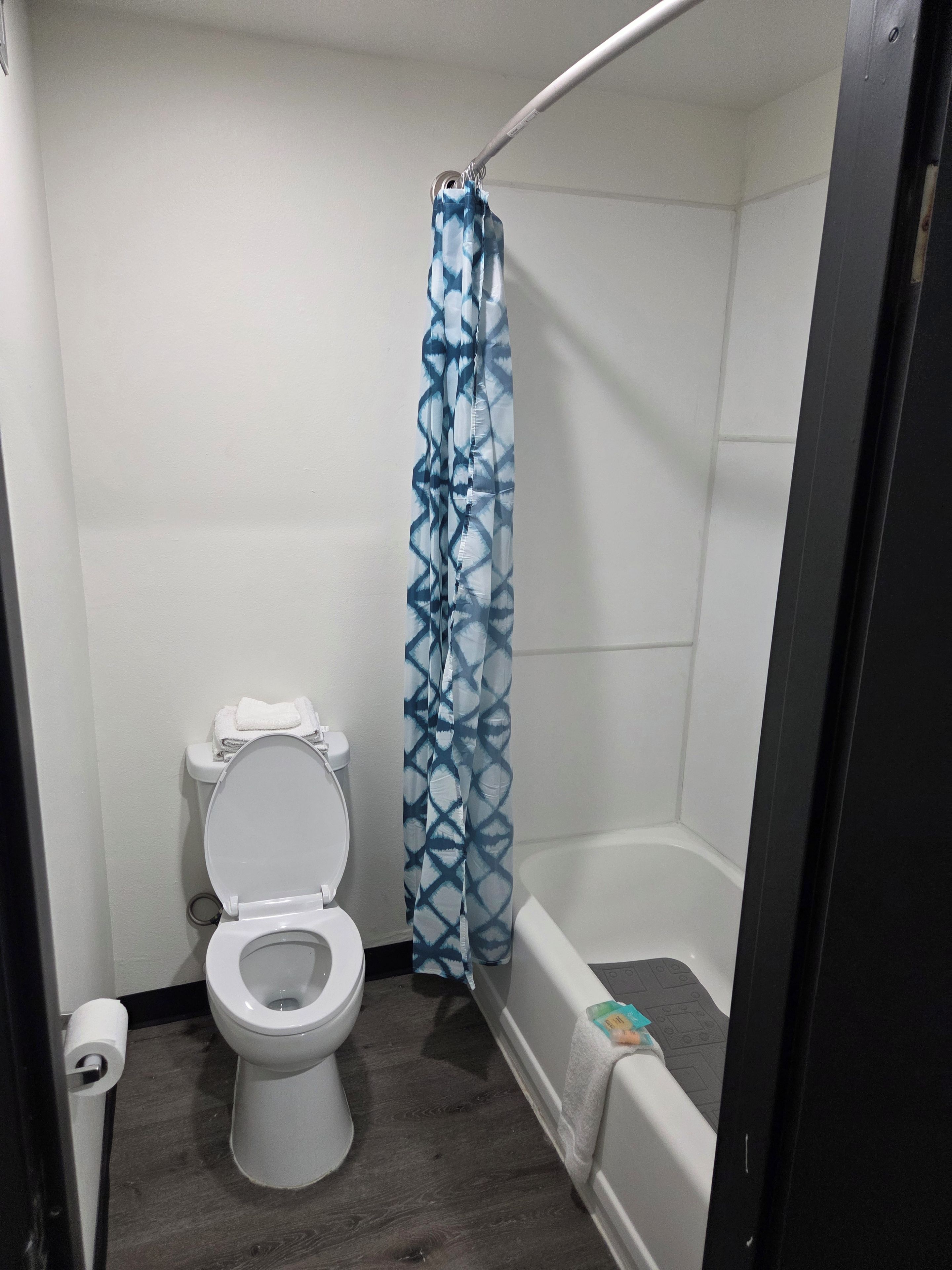 Un baño pequeño con inodoro, cortina de ducha y bañera.