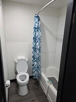 Un baño pequeño con inodoro, cortina de ducha y bañera.