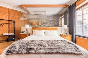 A modern hotel room with a large bed, wooden headboard, and a view through a glass partition to the outside. - The Mark México (Mexico City)