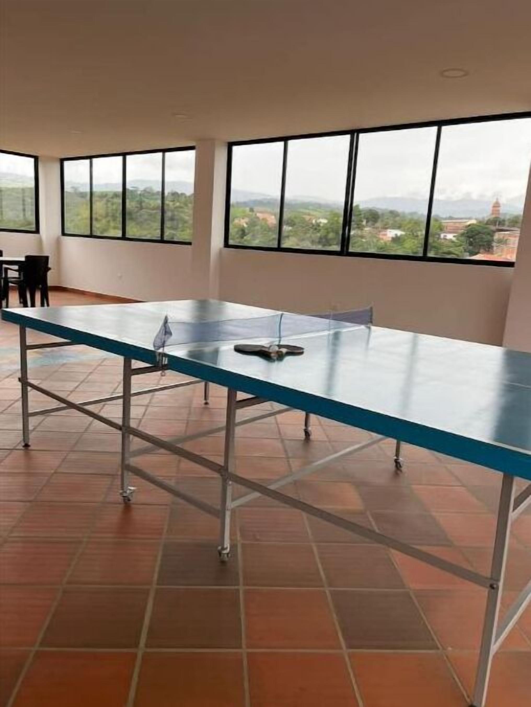 Une salle de conférence dotée d’une longue table, de chaises et de grandes fenêtres donnant sur un panorama urbain.