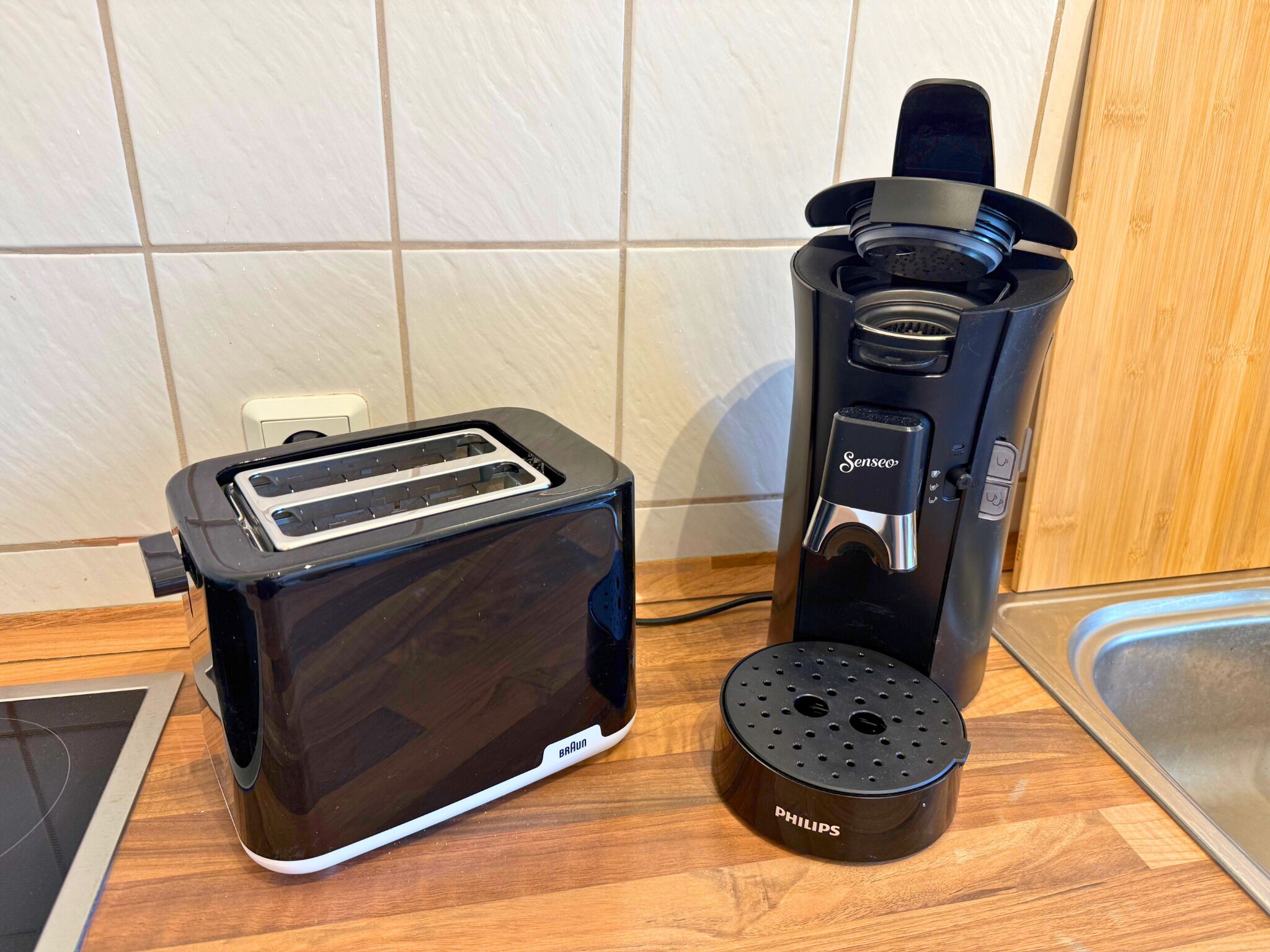 Eine Küche mit Schwarzbrenner, Kaffeemaschine und einem Philips Wasserkocher auf einer Holzauszug.