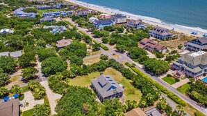 Luchtbeeld van een kustgebied met woonhuizen, wegen en een strand.