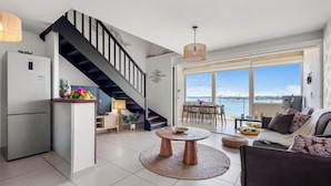 A modern living space with a staircase, a dining area, and a view of the sea. - Lagoon view & Sunset ! Full unit 2BDR 2,5BTH (SAINT MARTIN)