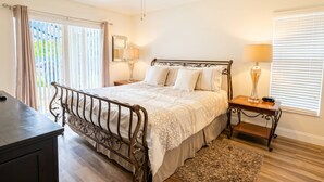 A bedroom with a bed, bedside tables, a desk, and a ceiling fan. - 4BR Pool Home at Lake Berkley (Kissimmee)
