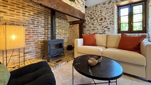 A cozy living room with a brick fireplace, a sofa, and a coffee table.