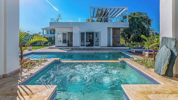 A modern house with a swimming pool, a covered patio, and a view of the surrounding landscape. - Palm Villa 4BR Luxe pool retreat (Sosúa)